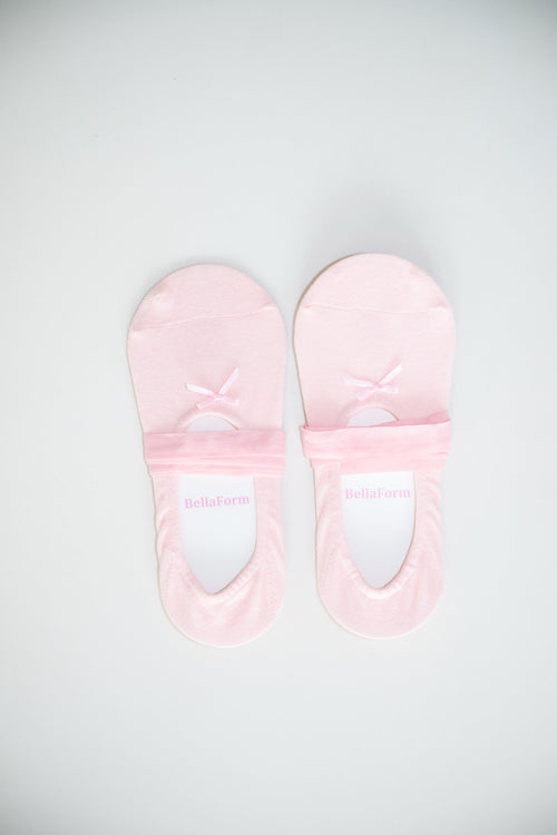 A pair of BellaForm ballet-laced grip socks in Ballet Pink, laid flat on a pale background with satin ribbons wrapped around the arch.